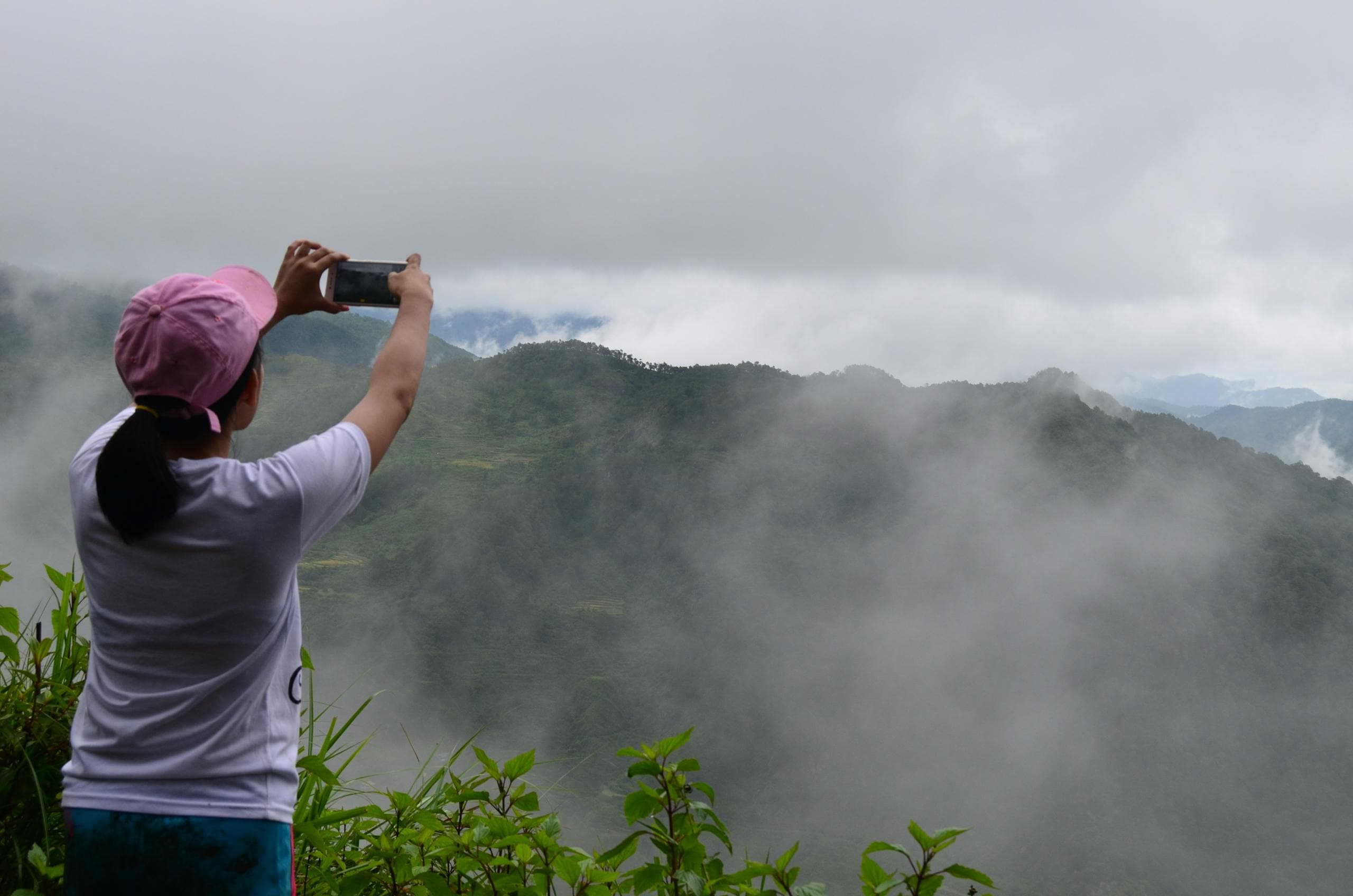 Person photographing misty mountains with a phone - perception, clarity, and field intelligence